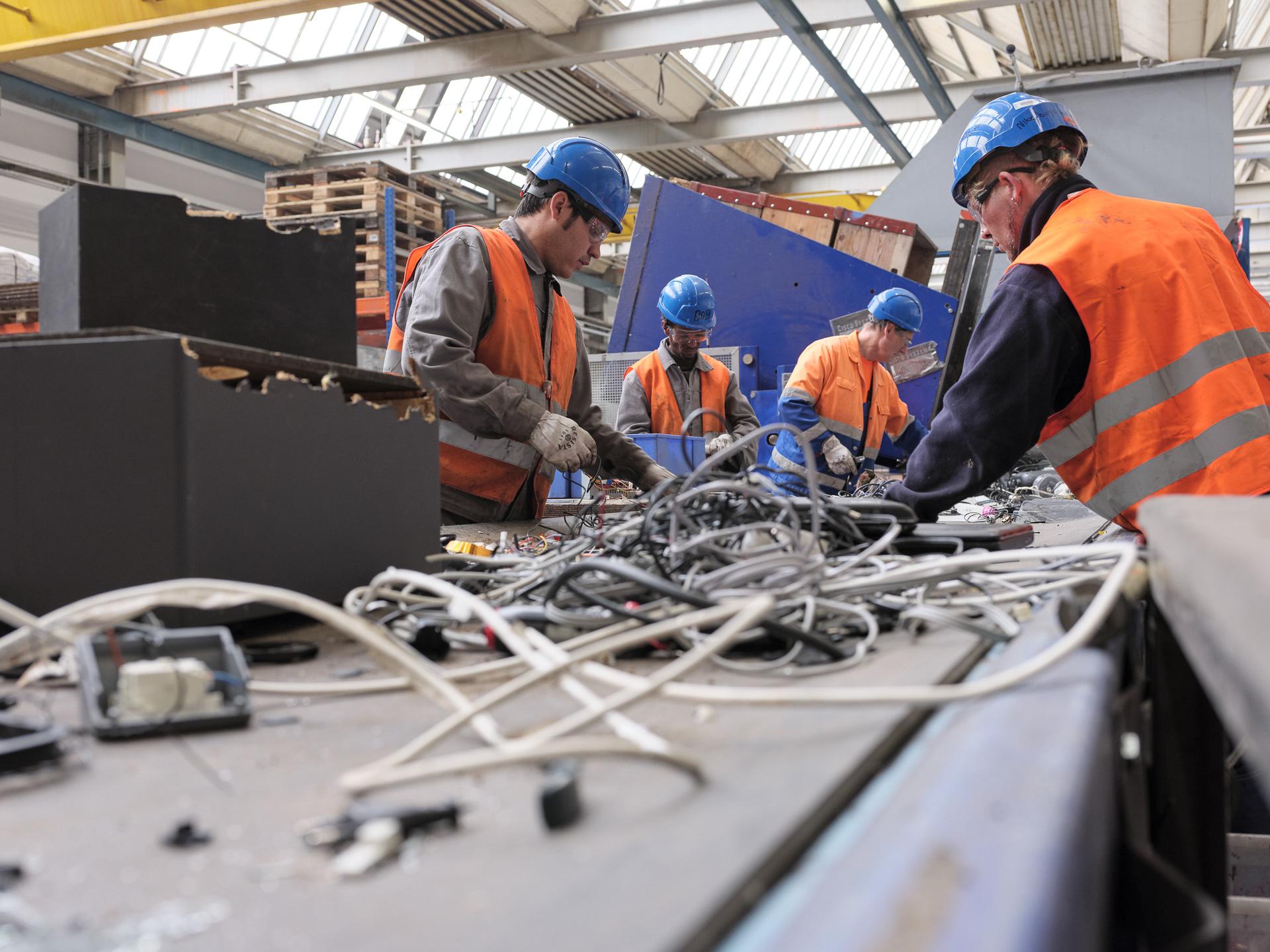 Altola Mitarbeiter helfen bei der Sortierung von Elektro- und Elektronikschrott.