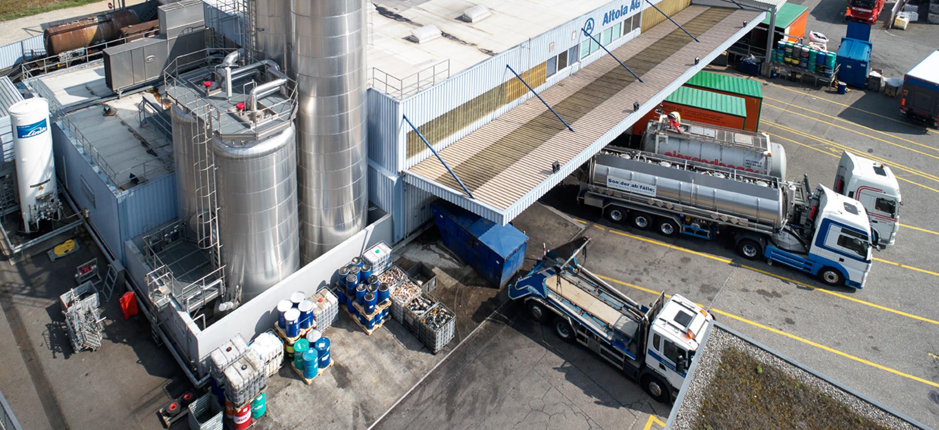 Der Standort Olten von Altola zeigt ein Industriegebäude mit mehreren angedockten LKW und Zylinderförmigen, riesigen Behältern aus Metall.